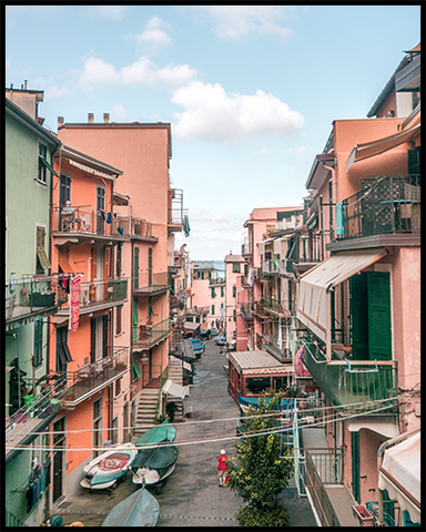 Manarola poster featuring a street in the town with pink and green-colored houses. Create an inspiring photo gallery with our Cinque Terre Collection.